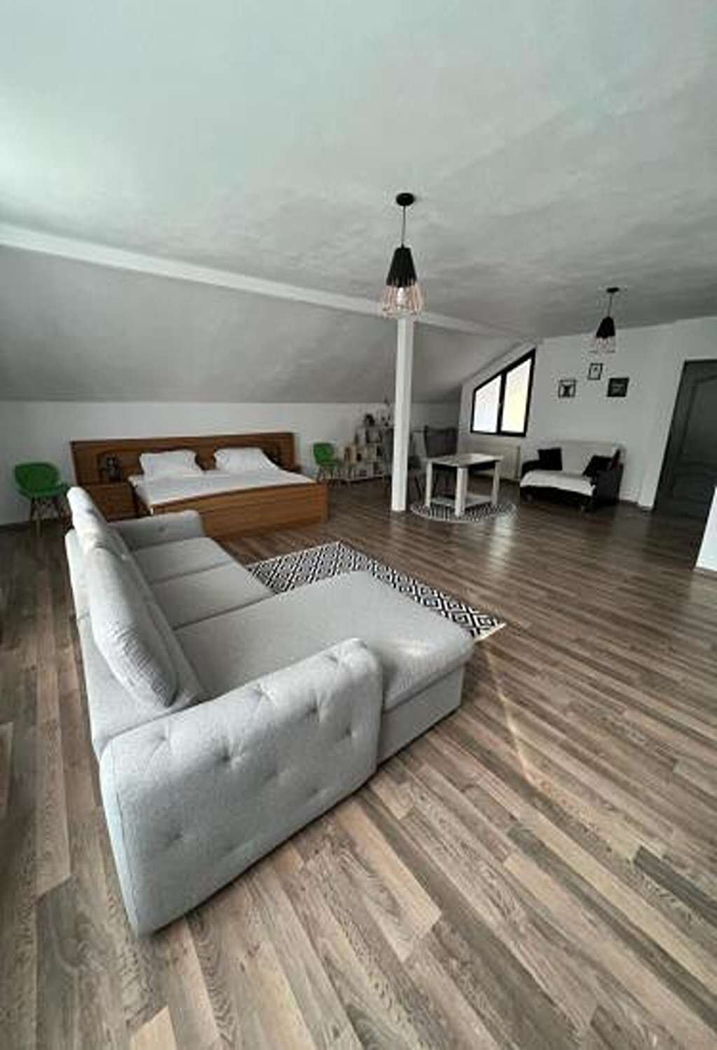 Apartament spațios la mansardă, cu canapea mare și zonă de dormit
